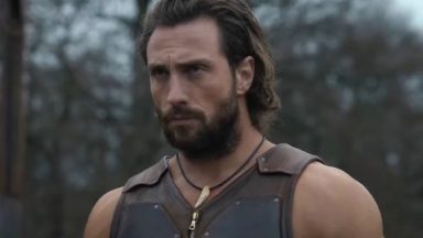 close up of well-muscled bearded man glowering in the woods