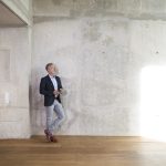 Business-like man standing in a concrete loft space