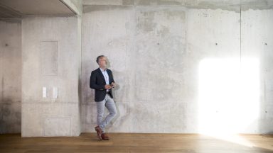 Business-like man standing in a concrete loft space