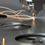 CNC laser skipping across a metal surface, leaving light trails in long exposure.