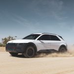 A white Hyundai Ioniq 5 XLT drives across the desert, kicking up sand