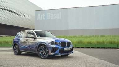 A BMW X5 has been wrapped by an artist and parked in front of a frosted glass building