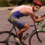 man in bicycle in cycling shorts and helmet