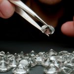 CLOSE UP: Jeweler looking a diamonds on the work table - stock photo