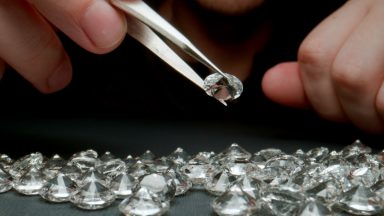 CLOSE UP: Jeweler looking a diamonds on the work table - stock photo