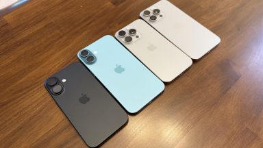 Four iPhones on a wood table