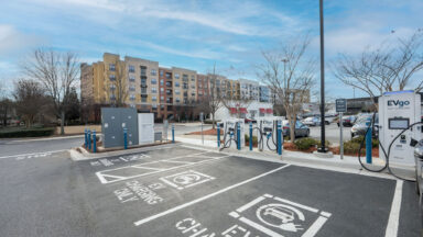 An EV charging location with multifamily buildings in the background.