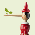 Image of a Pinocchio doll with a long nose and a small green sprig at the end.