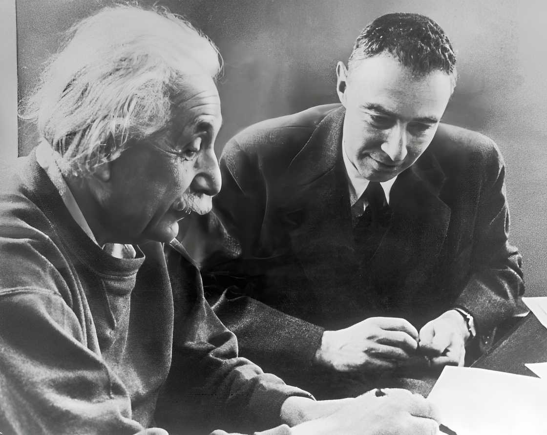 Albert Einstein telling something to Robert Oppenheimer about his attempts to explain the matter in terms of space in 1947