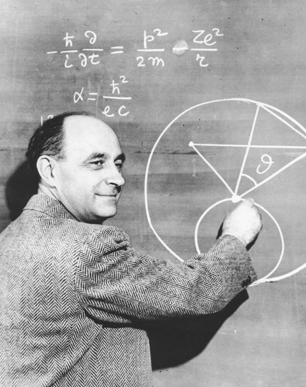 Italian-born physicist Dr. Enrico Fermi draws a diagram at a blackboard with mathematical equations. circa 1950.