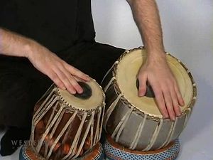 Observe a man playing the tabla