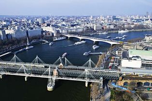 The Hungerford Railway Bridge (foreground) spanning the River Thames, London.