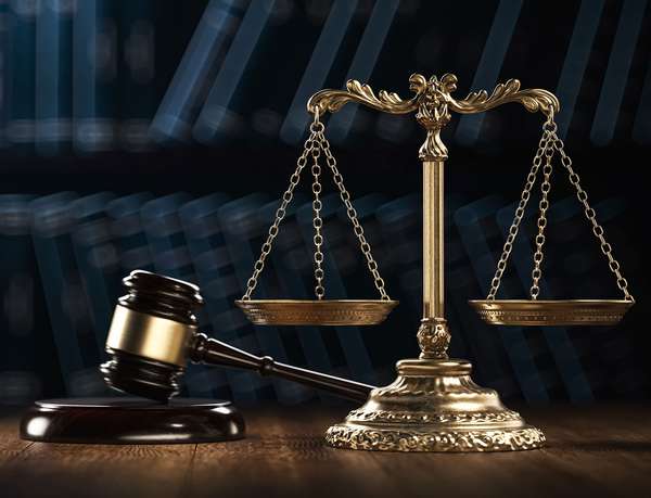 Law legal system crime concept with gavel and scales of justice with books in the background. (mallet, judicial system).