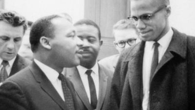 Martin Luther King, Jr. (left of centre) and Malcolm X (right) waiting for a press conference, 1964.