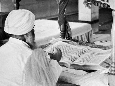 Priest worshiping the Ādi Granth