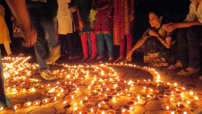 People lighting traditional earthen lamps during the Hindu festival Diwali in India. flame