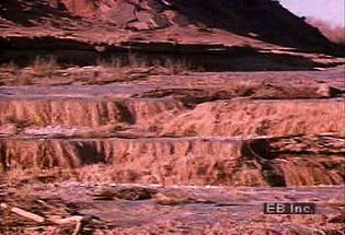 Watch a desert thunderstorm and resulting flash flood scour the sandy soil and terrain