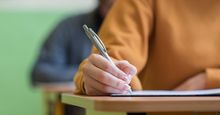 Students taking exam in classroom (testing, school, education).