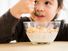 Little girl eating a bowl of cereal with milk. Cheerios Breakfast