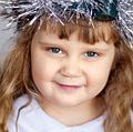 Saint Lucia Day. Young girl wears Lucia crown (tinsel halo) with candles. Holds Saint Lucia Day currant laced saffron buns (lussekatter or Lucia's cats). Observed December 13 honor virgin martyr Santa Lucia (St. Lucy). Luciadagen, Christmas, Sweden