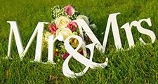 Sign for wedding "Mr & Mrs" (mister and missis) with flowers in the grass