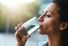 Shot of a woman drinking a glass of water at home. Drink sip hydration