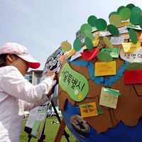 Earth Day. Environmentalism. Girl writes on globe and participate in the 2008 Earth Day event at Seoul City Hall on April 20, 2008 in Seoul, South Korea. UN Earth Day, vernal equinox, environmental movement, sustainability