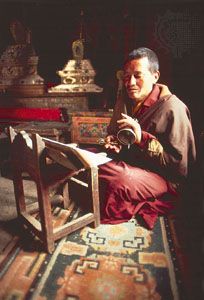 Tibetan Buddhist monk reading with handbell in Lamayuru monastery, Ladakh, India