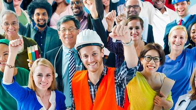 A group of diverse individuals, who represent various occupations, stand with their arms raised in the air. labor day; laborers; construction worker; teacher; nurse; doctor; assistant; office staff; blue collar; workforce