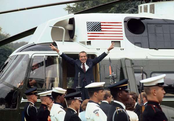 President Richard M. Nixon smiles and gives the victory sign as he boards the White House helicopter after his resignation on August 9, 1974 in Washington, D.C.