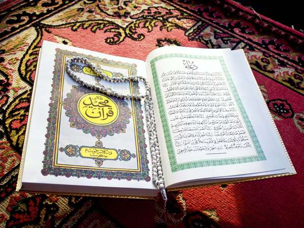 Prayer beads on Quran or Koran written in Arabic Islam's sacred and liturgical language. text, words, Ramadan