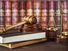 Wood gavel, soundblock, scales and stack of old books against the background of a row of antique books bound in leather.