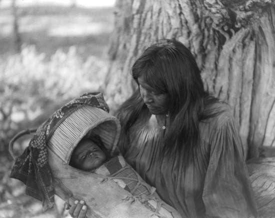 Mizheh and Babe, portrait of an Apache woman holding a child in a cradleboard, photograph by Edward S. Curtis, c. 1906.