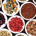 Herbal teas in white porcelain dishes over a bamboo background.