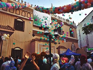 Young men throw balloons and glitter from above the mosque at the celebration Eid Al-Fitr after prayers playing with balloons outside of Al-seddeeq mosque, Al-Mansourah, Egypt. 17 July 2015.