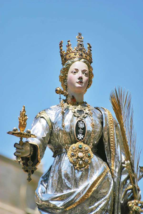 Saint Lucy. St. Lucia's Day. Saint Lucia Day. Feast of Saint Lucia procession in Syracuse, Italy, December 13. Marks beginning of Christmas season. Christian saint, virgin and martyr died 304 when her neck was pierced by a sword. Luciadagen