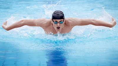 Man swimming the butterfly stroke in pool.  (swimmer; athlete)