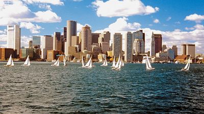 Sailboats in Boston Harbor in front of the financial district of Boston, Massachusetts, USA