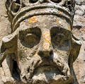 Weathered stone sculpture of a king's head on the side of a Church in Somerset, England. English royalty