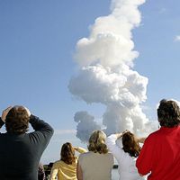 After a perfect launch, spectators try to catch a last glimpse of Space Shuttle Columbia, barely visible at the top end of the twisted column of smoke.