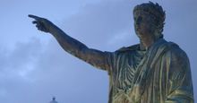 Statue of of the Roman emperor Nero with the lighthouse in the background at Anzio, Lazio region, Italy