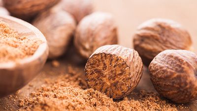 Ground nutmeg and nutmeg seeds. Herbs, spices