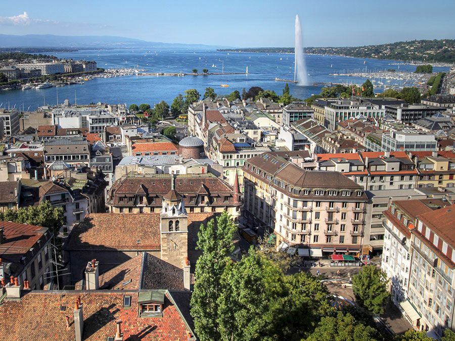 Aerial view of Geneva, Switzerland from the north tower of St-Pierre Cathedral over the city's waterfronts on both sides of Rhone river as it flows out of Lake Geneva (Lake Leman). Most of the city's landmarks are visible, starting with the famous Jet D'E