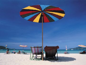 Deck chairs under a beach umbrella.