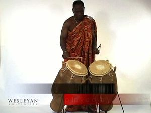 Observe a man playing the atumpan, a talking drum of the Asante people of West Africa