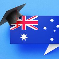 Graduation cap sitting over a speech bubble with an Australian flag on a blue background. (education)