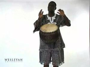 See a man playing a 'calabash drum'