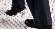 Man in Suit Walking on Eggshells. Idiom egg shell figure of speech