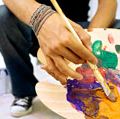 Close-up of a palette held by a man. Mixing paint, painting, color mixing.