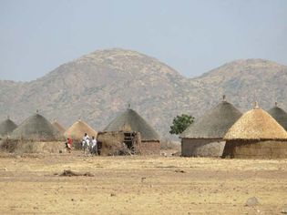 Tukuls—round huts made of mud, grass, millet stalks, and wooden poles, with thatched conical roofs—are a common type of rural housing in South Sudan.